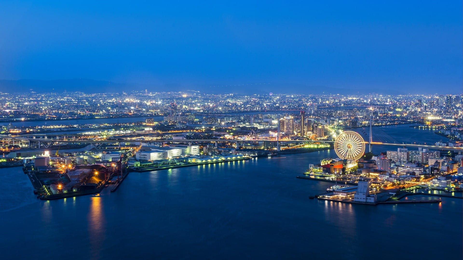 Osaka di malam hari: di latar depan adalah pelabuhan, di belakangnya adalah kota.