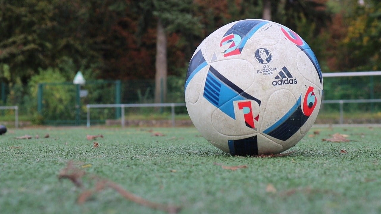 Bola sepak dengan iklan dari Adidas dan UEFA terletak di lapangan sepak bola.